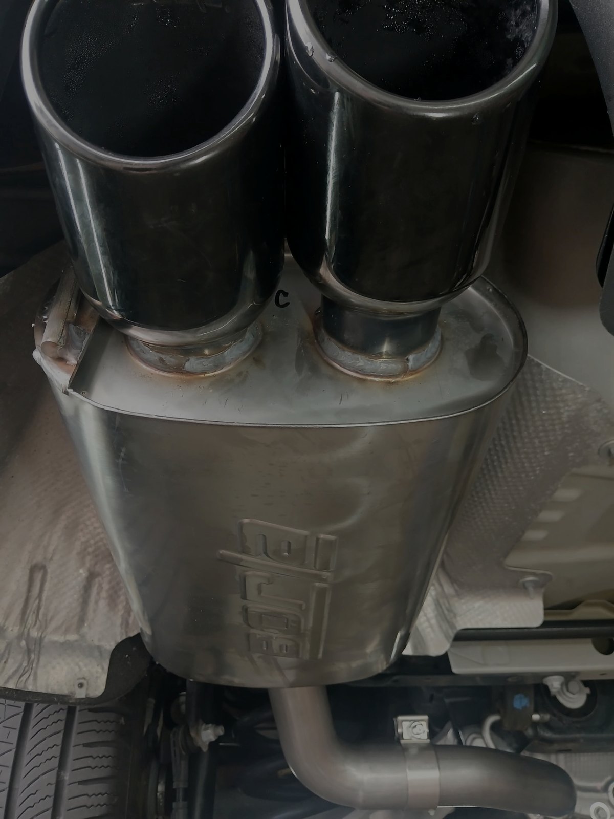 Polished dual exhaust tips on a stainless muffler